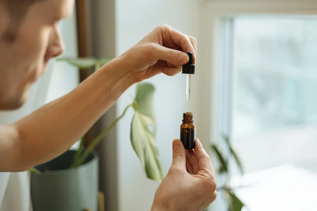Close up of a man holding a pipette of CBD oil.