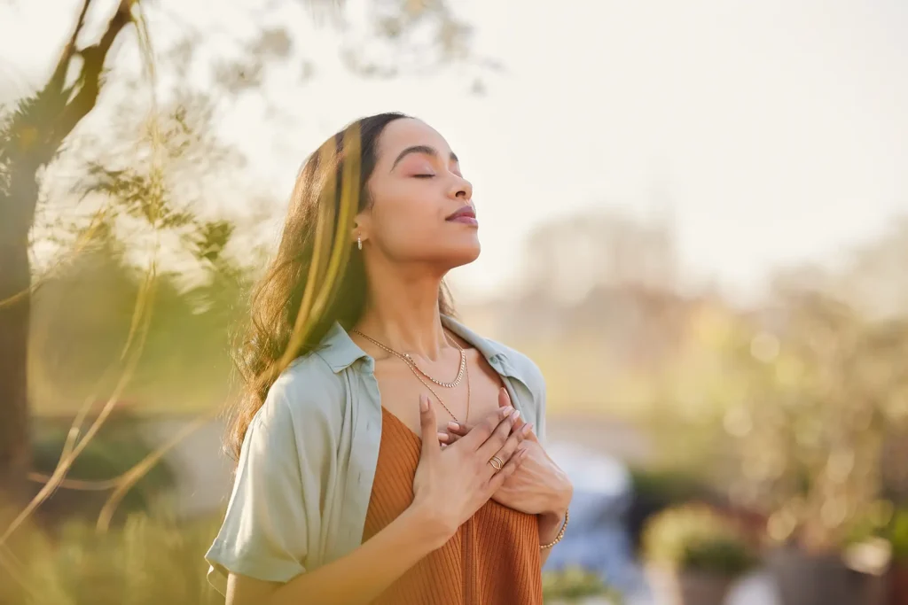 Young women taking a deep breath outside.