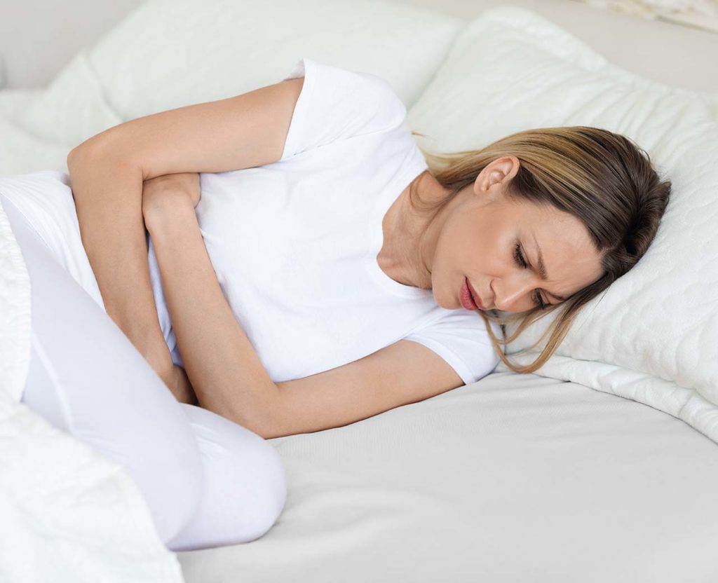Sick white woman suffering from abdominal pain in the morning