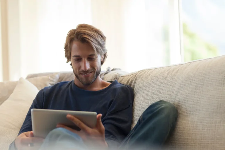 Man sitting on a sofa using his tablet