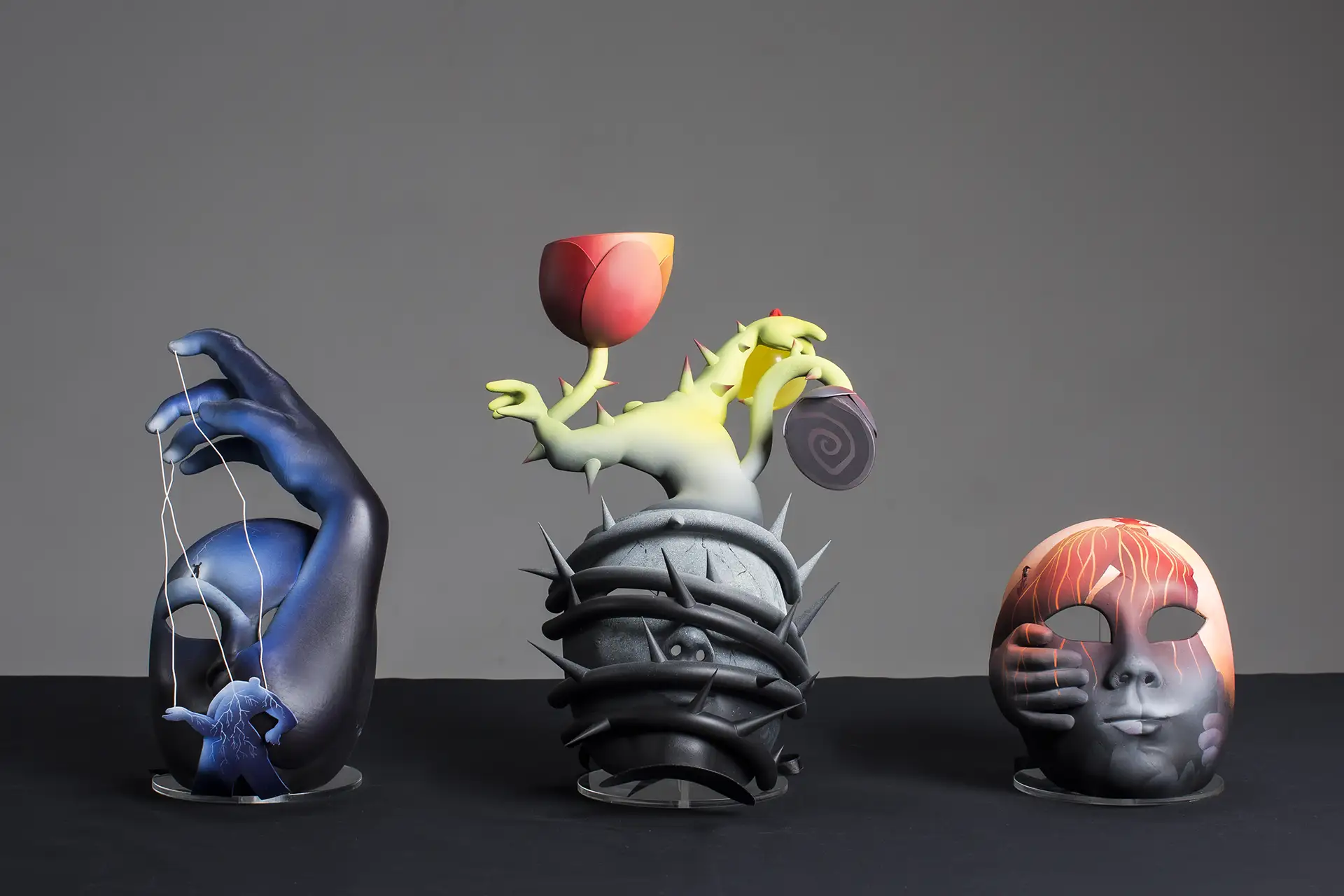 Three masks on display representing different chronic pains from the art series Pain Unmasked