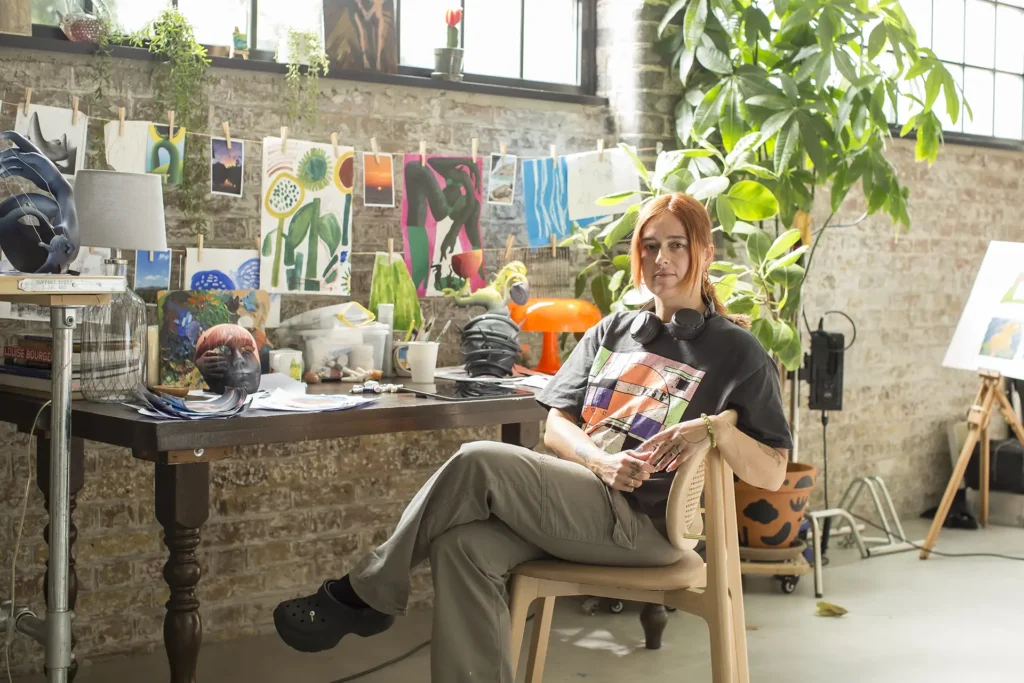 Artist Hayley Wall from Pain Unmasked sits in her studio.