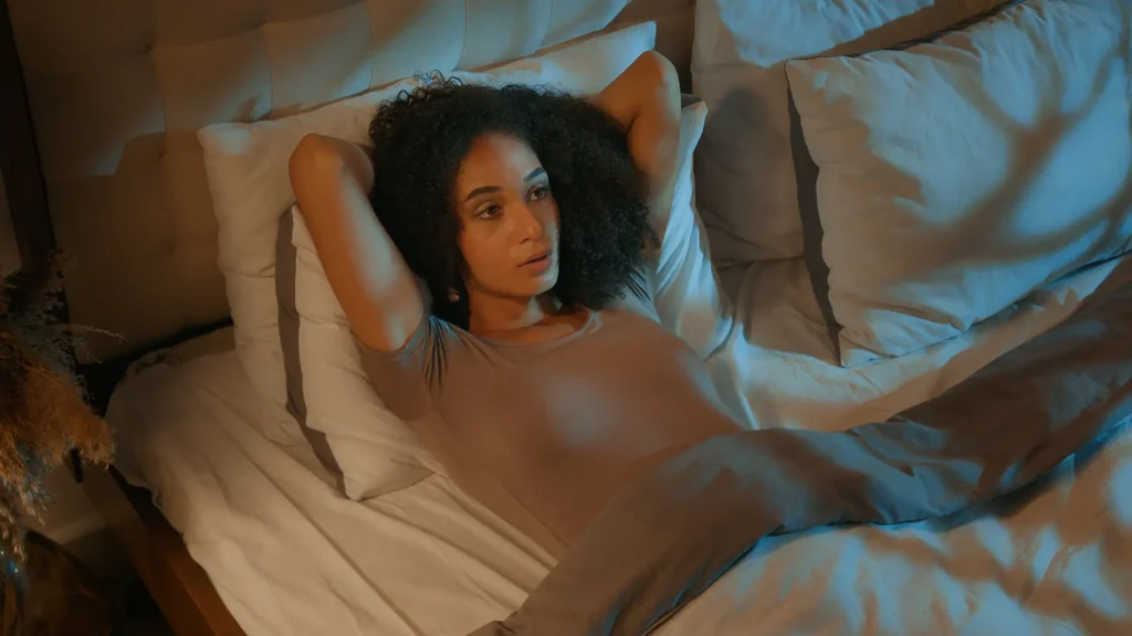 A young women lying in bed wide awake.